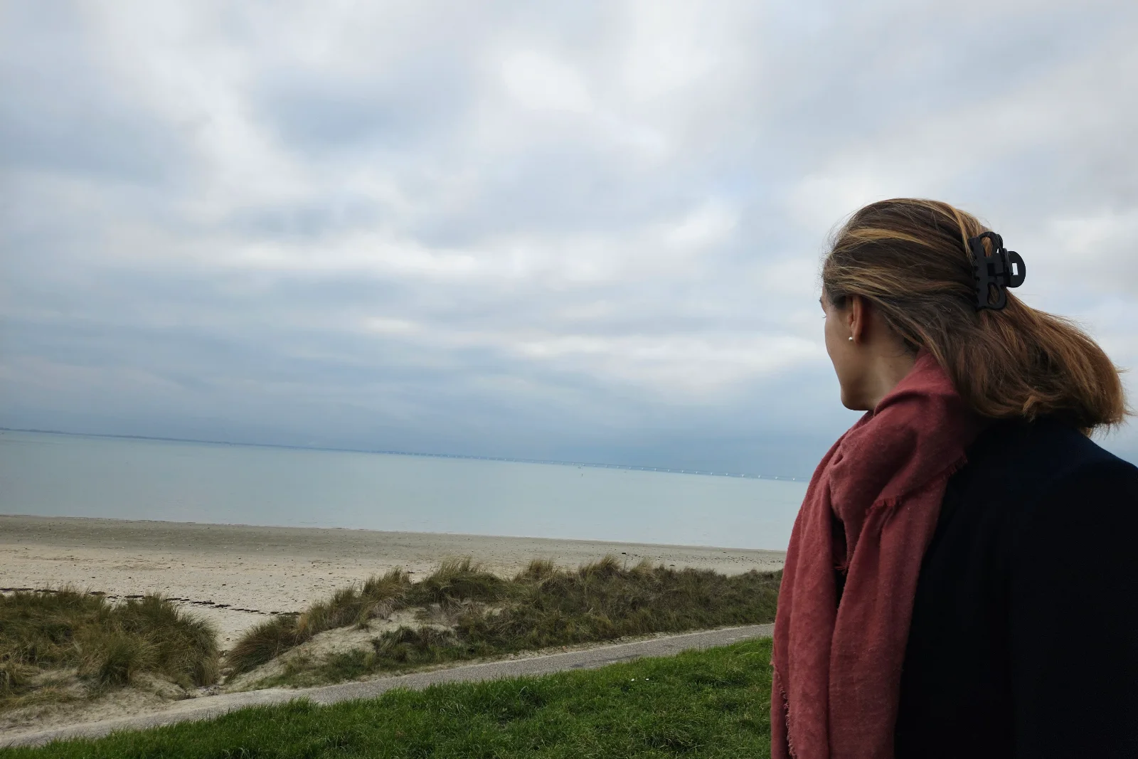 Jorinde kijkt uit over zee en strand tijdens een rustig moment.